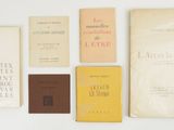 several books are lined up on a white surface