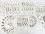 un grand nombre de cuillères et de fourchettes en argent disposées sur une table