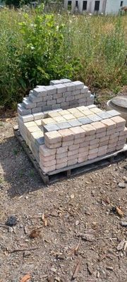a pile of bricks sitting on a pallet in the middle of a field