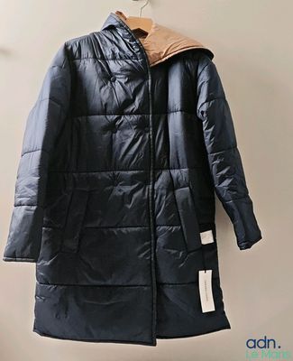 l'image d'un manteau suspendu à un cintre sur un mur