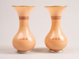 pair of yellow vases sitting on top of each other on a white surface