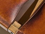 close up view of a brown leather table with a wooden handle