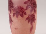 a pink vase with purple flowers on it on a white background