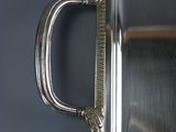 a silver tray with a handle on it on a table