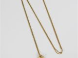 un collier plaqué or avec un pendentif en pierre verte