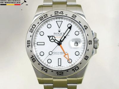 une montre Rolex avec un cadran blanc et une trotteuse orange