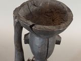 a black vase that has a man holding a bowl on it