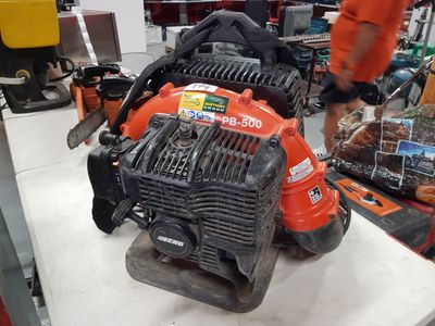 a man working on a lawn mower in a shop
