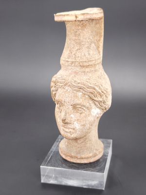 une image représentant un vase orné d'une tête de femme