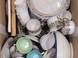 une boîte en carton remplie d'assiettes, de tasses et de soucoupes