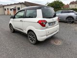 une petite voiture blanche garée dans un parking