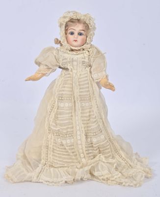 a close up of a doll wearing a white dress and bonnet