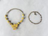 two bracelets and a bracelet with a yellow bead on a white surface