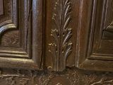 carvings on the side of a large wooden cabinet in a room
