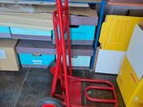 a red hand truck that is sitting on the floor