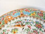 a colorful plate with a bird on it on a table