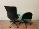 two office chairs sitting next to each other on the floor