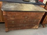 an old dresser with a black top in a room