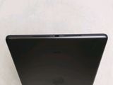 the back of a black laptop computer sitting on top of a white table