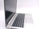 a silver laptop with a black keyboard on a white surface