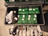 many pairs of tennis shoes on a shelf in a store