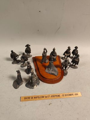 des figurines représentant un groupe de personnes assises sur une plaque en bois