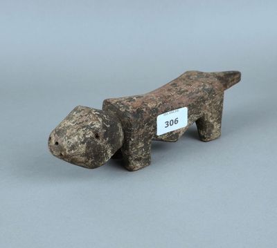 une vieille figurine de chien en bois à laquelle est accrochée une étiquette