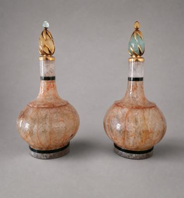 pair of vases with gold and green decorations on top of them