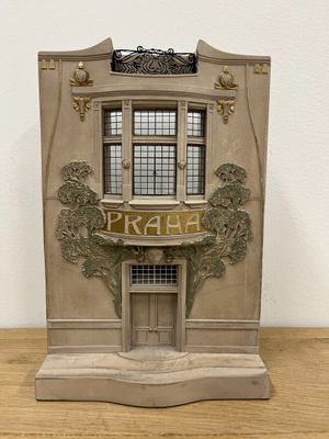 a statue of a building with a sign on the front of it