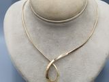 a white mannequin with a gold necklace on top of it