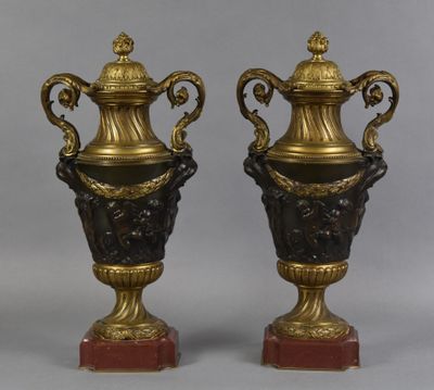 paire de vases anciens en bronze et noir, posés sur des socles en marbre rouge