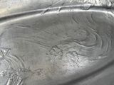 a silver plate with a design on it