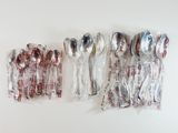 five silver spoons and two silver spoons wrapped in plastic
