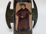 a small vase with a picture of a man on it