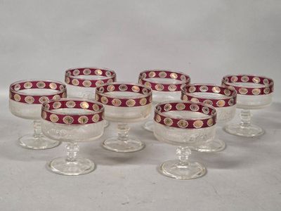 six wine glasses with red and gold designs on them sitting on a table