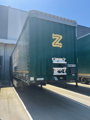 a green semi truck that is parked in front of a building