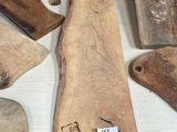 several wooden cutting boards on a table with tags on them