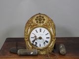 une horloge en or posée sur une table en bois