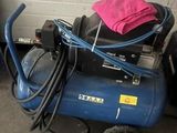 un compresseur d'air bleu sur lequel est posée une serviette rose