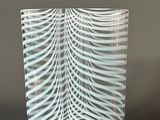 a glass vase that has a wavy design on it