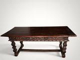 an old wooden table with carved legs and a wooden top