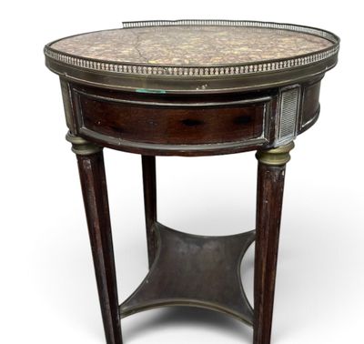 une table ronde avec un plateau en marbre et des pieds en bois