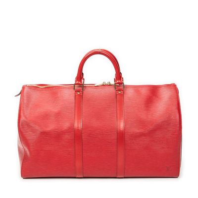 a red duffel bag sitting on top of a white surface