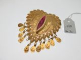 une image représentant une broche en or ornée d'une pierre rose au centre