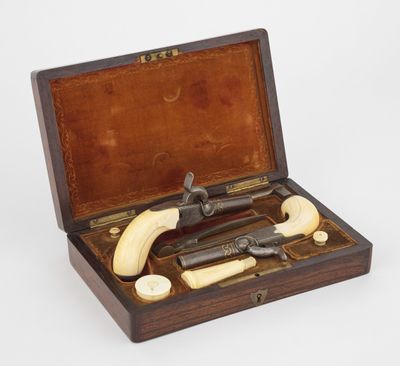 une image représentant une boîte en bois contenant un ensemble de couteaux et une pipe