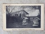 une vieille photo en noir et blanc montrant des ruches devant une maison