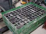 a green crate with holes in it sitting on a pallet