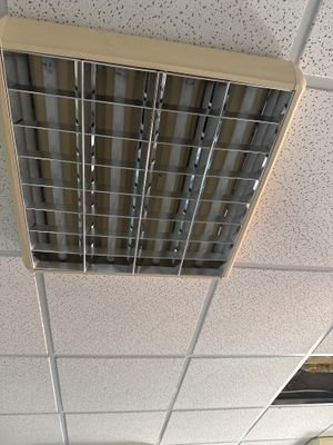 une bouche d'aération au plafond, au milieu d'une pièce équipée d'un ventilateur de plafond