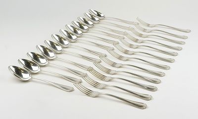 un service de six fourchettes et cuillères en métal argenté, présenté sur un plateau blanc