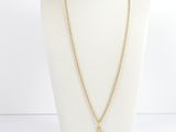 un collier en or avec un pendentif en forme de croix sur un mannequin